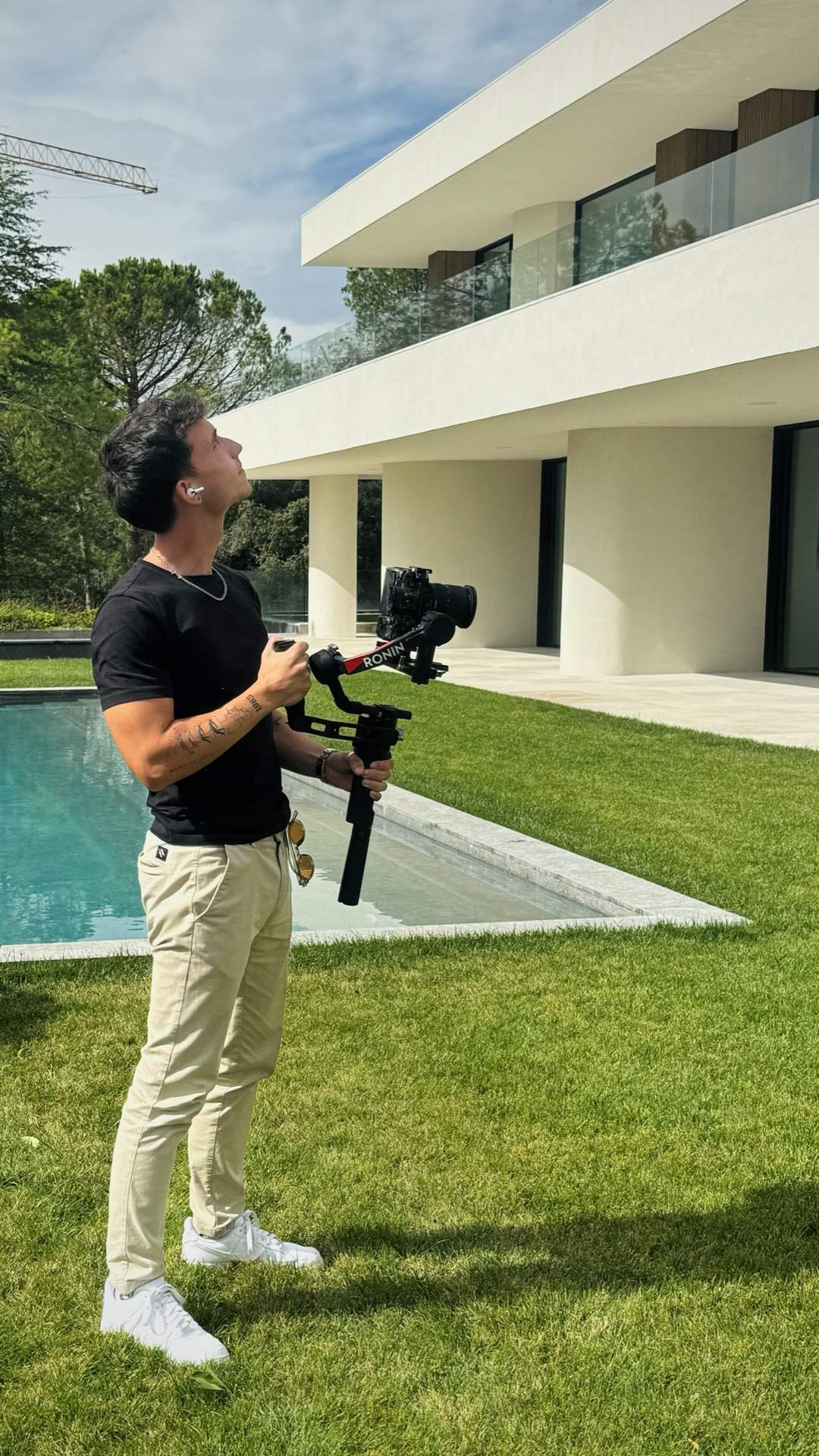 Filmmaker con gimbal junto a una piscina
